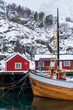 Fishing boats in the harbor with snowcapped red rorbuer