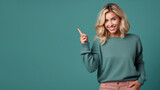 Fototapeta  - Happy blonde woman pointing her finger at copy space for promotion