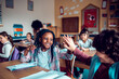 © Marko Geber - Little boy and girl high fiving in classroom