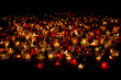 Many colorful lit memory candles in the dark. A beautiful display of colorful candles glowing in the night