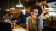 Portrait of smiling waitress standing at counter in coffee shop and looking at camera