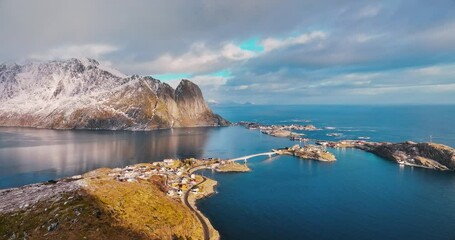Wall Mural - Aerial view of snowy rocks, islands with rorbuer, sea, bridge, mountains, road, sky with clouds at sunset in winter. Beautiful top drone view of Reine and Hamnoy village, Lofoten islands, Norway	