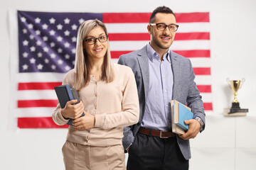 Canvas Print - Man and woman holding books in front of an american flag