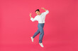 Portrait of carefree energetic young asian woman jumping and showing peace gesture