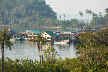 Wall Mural - A group of houses in a small bay, surrounded by rainforest, south of Koh Chang Island, in the Gulf of Thailand
