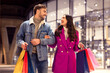 © Prostock-studio - couple shopping during winter spree and sales carrying bags outdoors