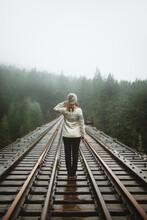 Back View Of Solitary Woman In Journey On A Foggy Vancouver Island Train Track