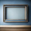 Close-up of an empty antique brass frame with an aged patina, resting on a navy blue shelf on a textured cream-colored wall in an empty room.

