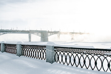 Wall Mural - Bridge is over frozen river. Embankment of the Ob river in winter in Novosibirsk frost day -40 degrees Celsius