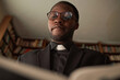Low angle portrait of Black man as priest reading Bible in church office preparing for Sunday sermon, copy space