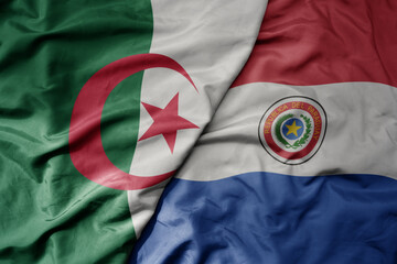 big waving national colorful flag of paraguay and national flag of algeria .