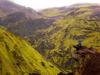 Incredible view of the Thórsmörk hills, Iceland, with a brave hiker on the mountain ledge