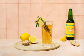 Wall Mural - Glass of fresh ginger beer with rosemary and lemon slice on beige background