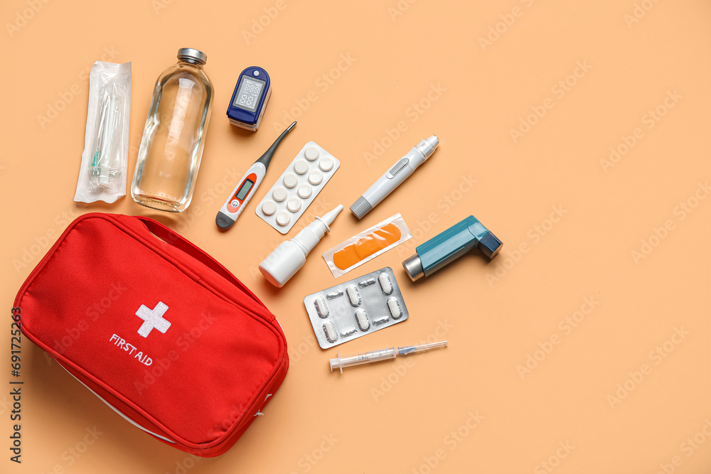 First aid kit and pills on beige background