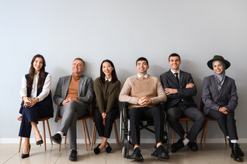 Poster - Business people sitting near light wall