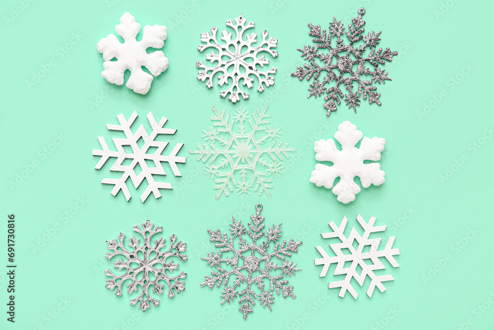Many Christmas decorative snowflakes on turquoise background