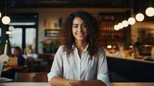 A content woman sits at a table in a cozy restaurant, her human face adorned with a smile as she takes in the stylish furniture against the backdrop of the intricate wall and elegant ceiling