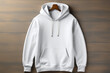 Blank white hoodie on wooden background, mockup for design.