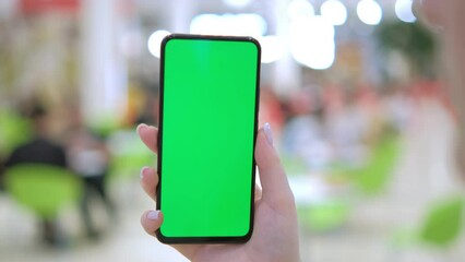 GREEN SCREEN CHROMA KEY Unrecognizable caucasian female using her phone inside mall. Vertical orientation. 4K