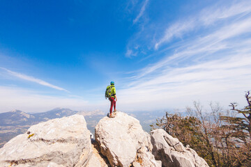 Wall Mural - climber with a backpack and a helmet goes along a mountain path in the mountains. Girl climber in the mountains.hiking with a backpack in the mountains.