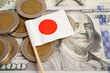 Japan flag on coin and banknote money, finance trading investment business currency concept.