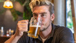 © SashaMagic - Man Enjoying Beer in a Cozy Bar Atmosphere