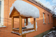 Wooden bird feeder, bird feeder house, hanging bird table with sunflowers seeds coverd snow in the cold snovy winter.