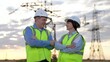 © SUPER FOX - Smiling engineers team with crossed arms stands against electric power generation plant in sunset field. Positive engineers with crossed arms at power distribution substation at twilight time