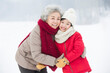 © Blue Jean Images - Happy grandmother and granddaughter embracing on the snow