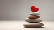 stack of red heart-shaped stones on a gray pebble beach. A zen and romantic concept for valentine’s day, spa, and meditation. A horizontal image with copy space and a calm sea in the background