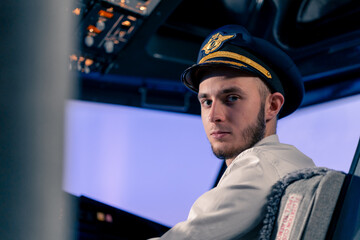 Portrait of serious airplane captain in uniform preparing for flight in flight simulator cockpit