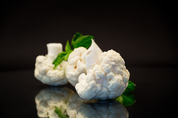 Canvas Print - slices of raw small raw cauliflower on black background