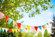 Colorful bunting flags strung in a lush green garden.