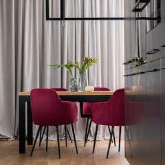 Poster - Stylish composition of kitchen and dining room open space interior. Minimalist ergonomic kitchen space. Velvet chairs, wooden table and personal accessories in the modern dining room. Template.