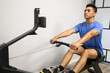 © ADDICTIVE STOCK - Man focused on rowing machine workout in gym