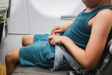 Child Buckling Seat Belt On Airplane