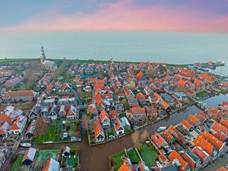 Poster - Aerial from the snowy little traditional village Hindeloopen at the IJsselmeer in winter at sunset in the Netherlands