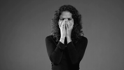 Dramatic desperate scene of woman pulling hair in black and white. Person feeling dread and preoccupation