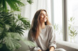 © colnihko - Happy young woman with a smile meditates among indoor plants at home. Mental health, Home gardening