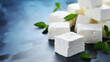 Cubes of feta cheese with mint leaves on a blue background