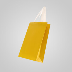 Wall Mural - Yellow shopping bag in air on light grey background