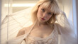 Beautiful blonde woman with bangs in a light transparent white dress and with thin fabric on the background creative studio shot