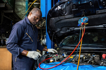 Auto mechanic monitor to check and fixed car air conditioner system in car garage. service car air conditioner in repair workshop. monitor tool on car engine ready to check and fixed air conditioner.