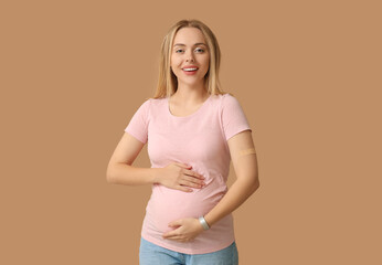 Canvas Print - Young pregnant woman after vaccination on beige background