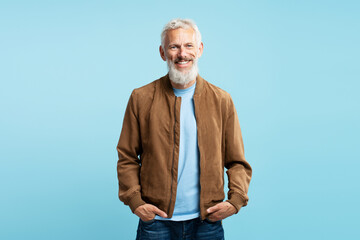 Portrait of smiling bearded gray haired man wearing stylish casual brown jacket looking at camera