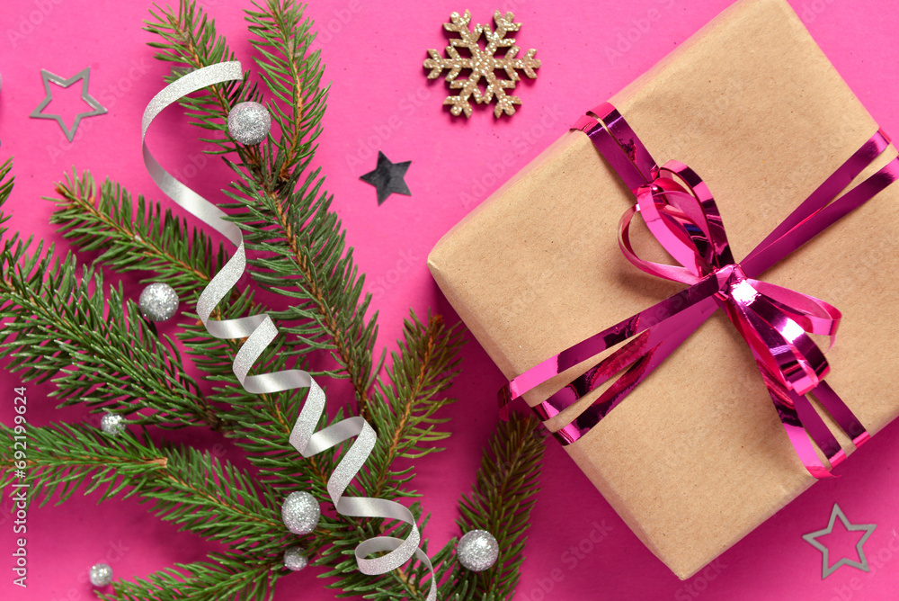 Gift box with Christmas tree branch and beautiful decorations on pink background