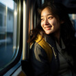 © J S - Happy smiling young urban Asian woman riding in public transport, looking out of bus window