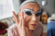 POV of male drag queen performer putting on fake eyelashes and doing makeup preparing for stage