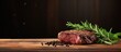Beef steak with rosemary on a wooden table. Copy space image. Place for adding text or design