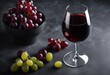© ArtisticLens - Red wine in a glass and ripe grapes on gray background top view